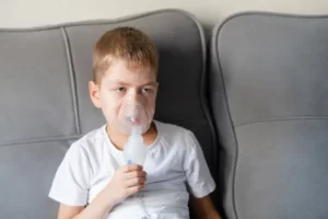 Picture of a little boy sits with an inhalation mask