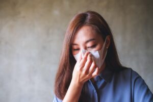 an asian woman putting on protective face mask for healthcare and covid 19 concept