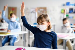 child with face mask back at school after covid 19 quarantine and lockdown